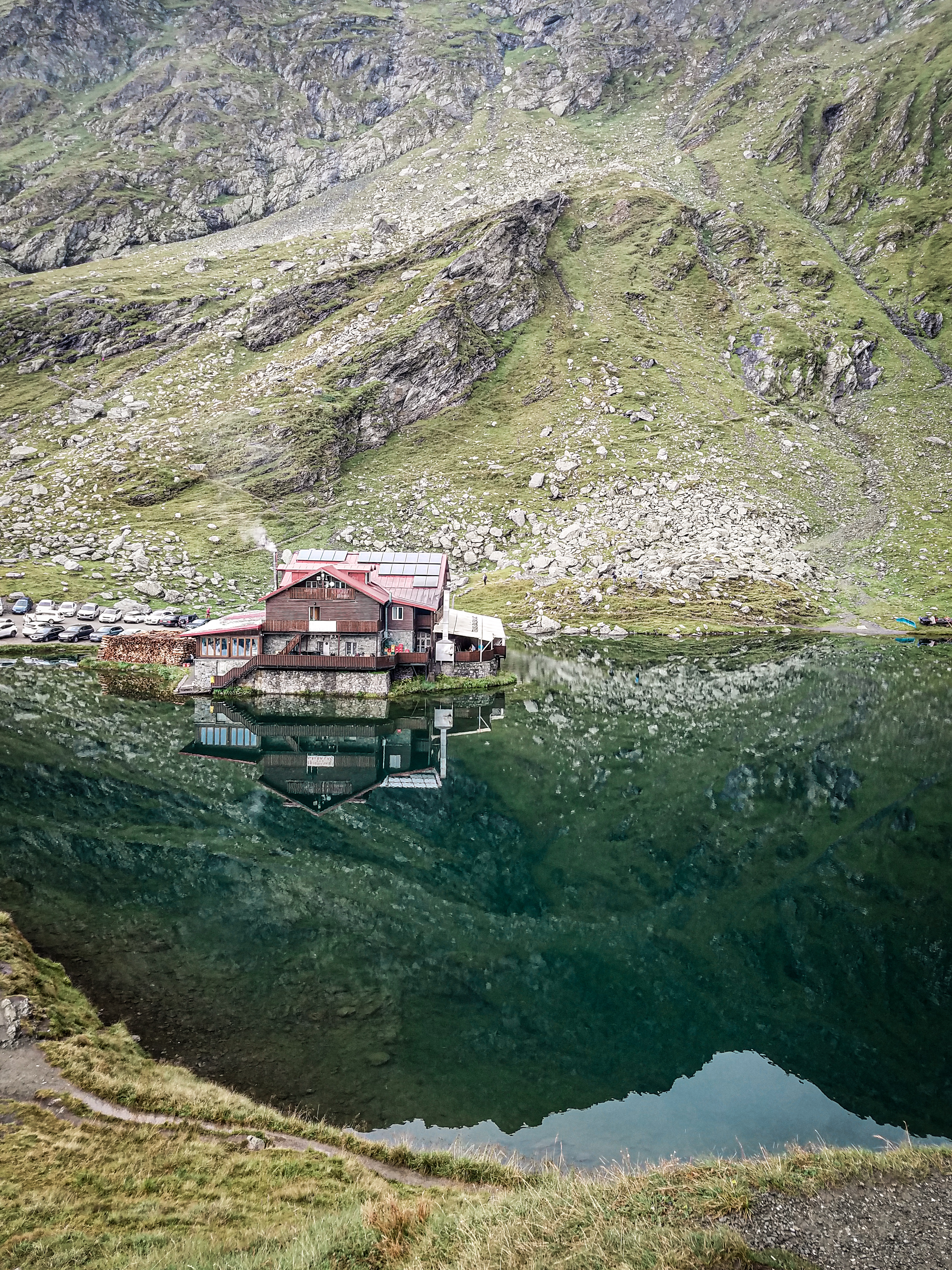 Jezero Bâlea v Făgăraș Mountains s horskou chatou, obklopené majestátními horskými vrcholy.